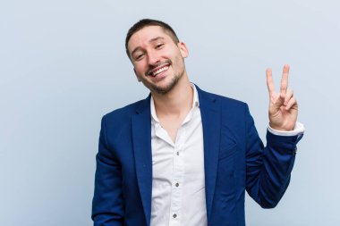 Genç beyaz adam neşeli ve kaygısız parmaklarıyla barış sembolü gösteriyor..