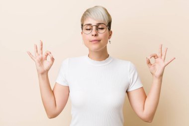Genç, otantik, beyaz gömlek giyen doğal bir kadın sıkı çalışma gününden sonra rahatlıyor. Yoga yapıyor..
