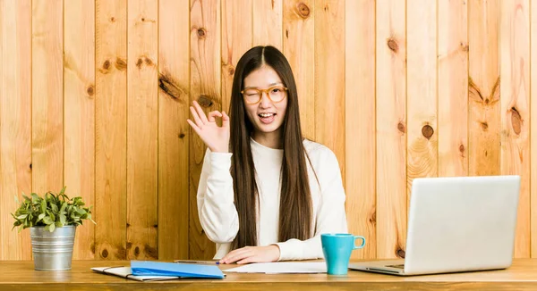 Joven Mujer China Estudiando Escritorio Guiña Ojo Sostiene Gesto Bien —  Fotos de Stock