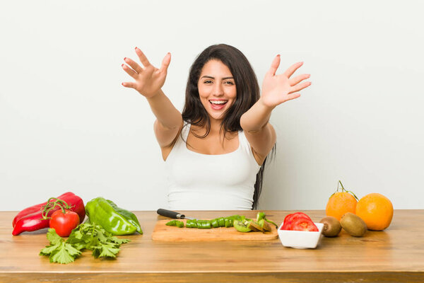 Молодая пышная женщина готовит здоровую пищу чувствует себя уверенно обнимая камеру
.