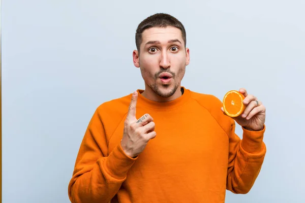 Joven Hombre Caucásico Sosteniendo Una Naranja Que Tiene Una Gran — Foto de Stock