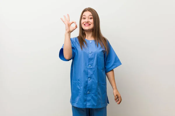 Νεαρή Νοσοκόμα Γυναίκα Ενάντια Ένα Λευκό Τοίχο Χαρούμενη Και Αυτοπεποίθηση — Φωτογραφία Αρχείου