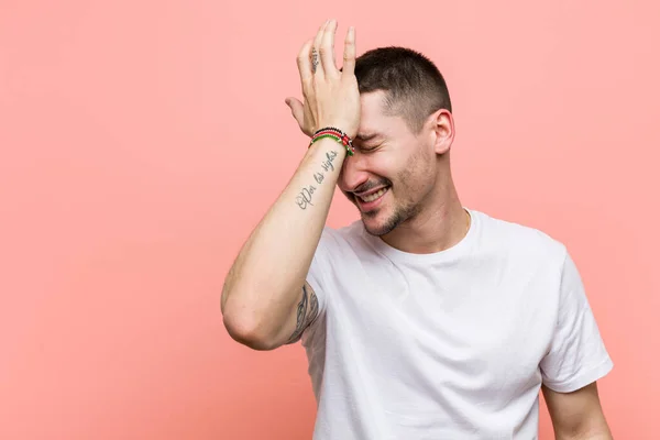 Young casual man forgetting something, slapping forehead with palm and closing eyes.