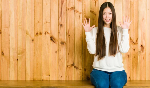 Jovem Chinesa Sentada Lugar Madeira Mostrando Número Dez Com Mãos — Fotografia de Stock