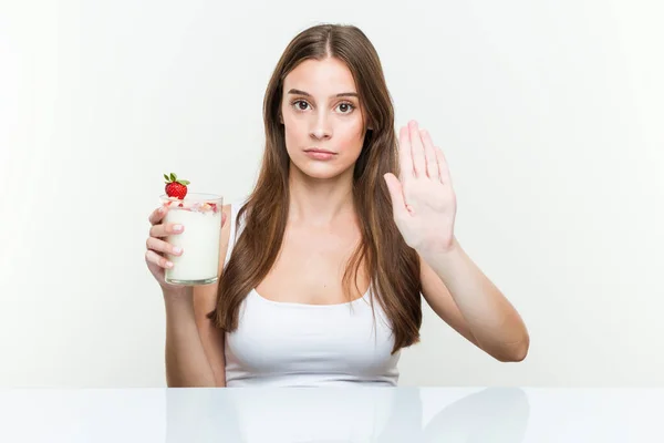 Mujer Caucásica Joven Sosteniendo Batido Pie Con Mano Extendida Mostrando —  Fotos de Stock