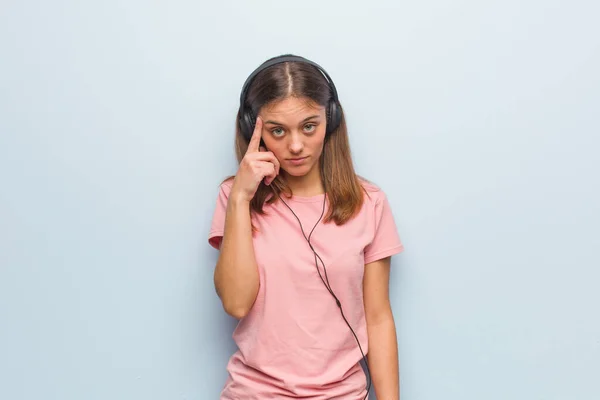 Fiatal Csinos Kaukázusi Gondolkodik Egy Ötleten Fülhallgatóval Hallgat Zenét — Stock Fotó