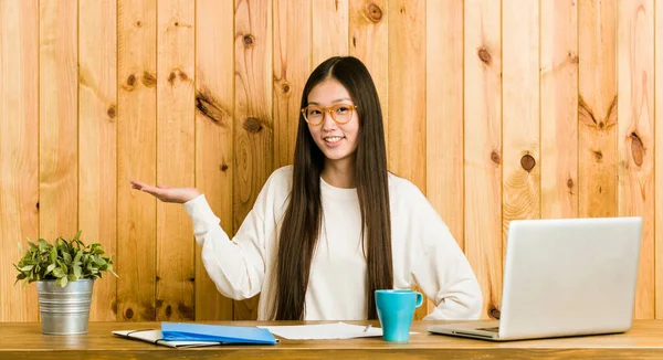 Joven Mujer China Estudiando Escritorio Mostrando Espacio Copia Una Palma —  Fotos de Stock