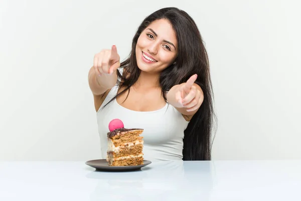 Jonge Spaanse Vrouw Eet Een Taart Vrolijk Glimlachen Wijzend Naar — Stockfoto