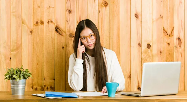 Young Chinese Woman Studying Her Desk Pointing Temple Finger Thinking — Stock Photo, Image