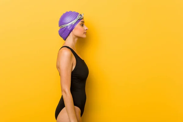 Young swimmer caucasian woman gazing left, sideways pose.