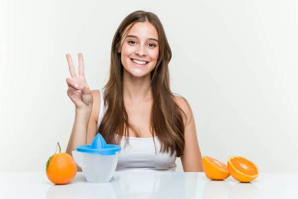 Ung Kaukasisk Kvinna Med Apelsinjuice Som Visar Nummer Två Med — Stockfoto