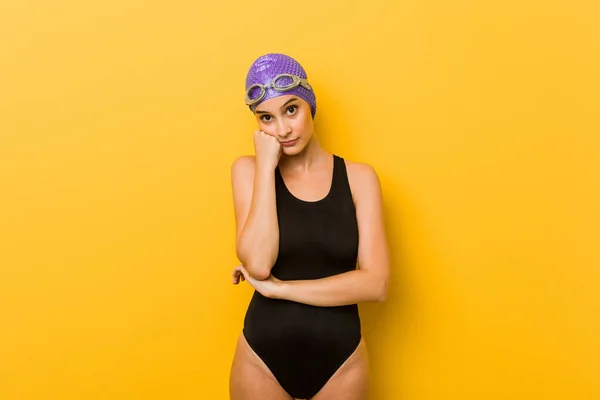 Young swimmer caucasian woman who feels sad and pensive, looking at copy space.