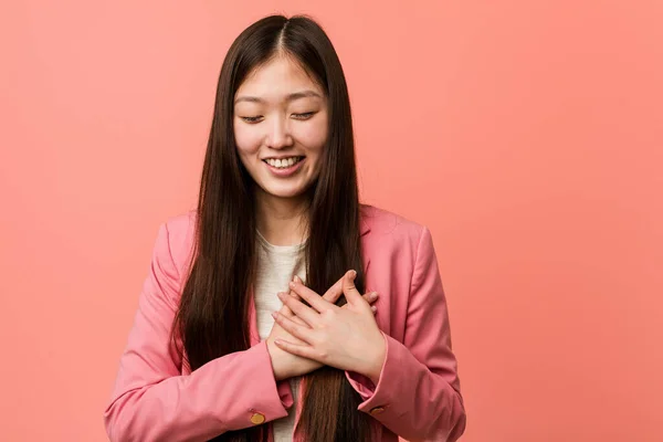 Junge Business Chinesin Rosafarbenen Anzug Lacht Und Hält Die Hände — Stockfoto