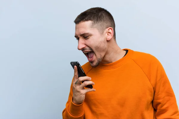 Young Caucasian Man Holding Phone Shouting Excited Front — Stock Photo, Image