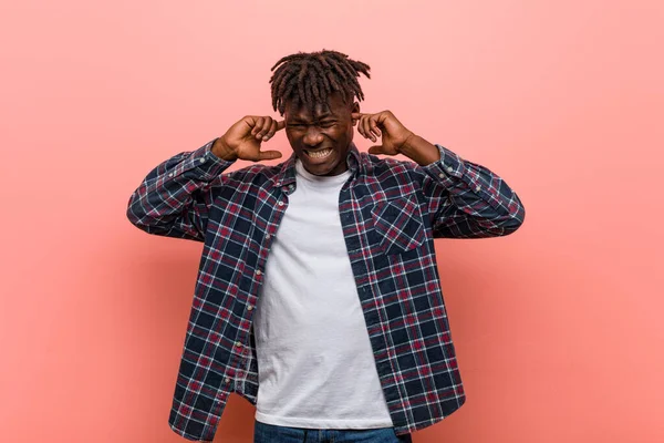 Young african black man covering ears with his hands.