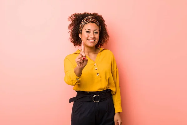 Молодая Африканская Американка Розовом Фоне Показывает Номер Один Пальцем — стоковое фото