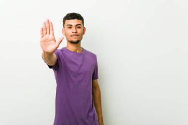 Genç İspanyol adam uzanmış el ile dur işareti gösteren ayakta, sizi engelleyen.