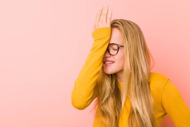 Sevimli genç kadın bir şey unutuyor. Alnına avuç içi ve kapalı gözlerle vuruyor..