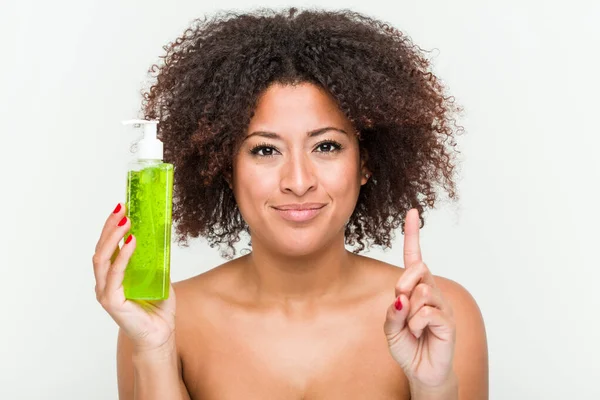 Young African American Woman Holding Aloe Vera Bottle Showing Number — Stock Photo, Image