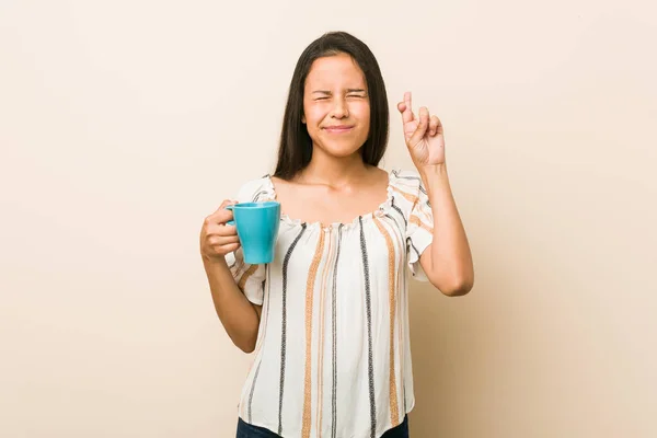 Mujer Hispana Joven Sosteniendo Una Taza Cruzando Los Dedos Para —  Fotos de Stock