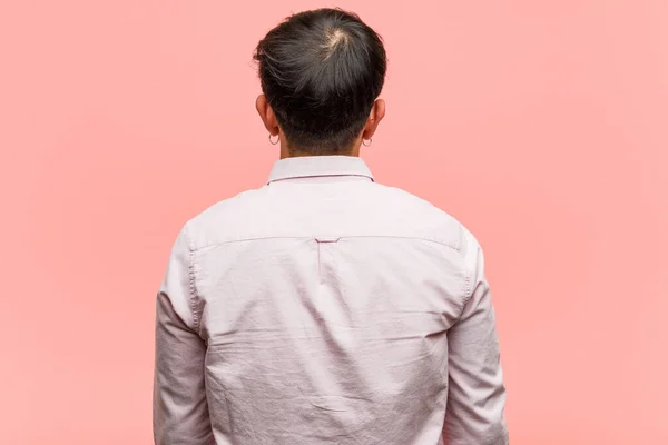 Young chinese man from behind, looking back