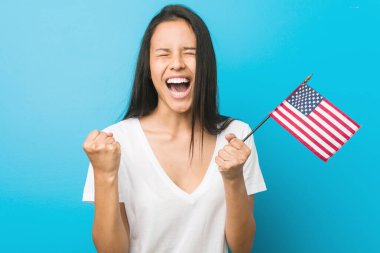 Amerika Birleşik Devletleri bayrağını tutan genç İspanyol kadın tasasız ve heyecanlı bir şekilde tezahürat yapıyor. Zafer konsepti.