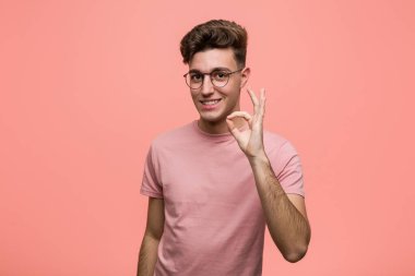 Genç, havalı, beyaz, neşeli ve kendine güveni tam bir jest yapıyor..