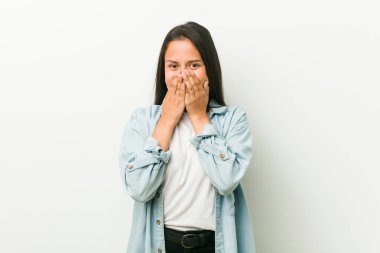 Genç İspanyol kadın bir şeye gülüyor, elleriyle ağzını kapatıyor..