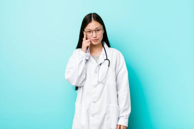 Genç Çinli doktor, tapınağı parmağıyla işaret ederek, düşünerek, bir göreve odaklanmış..