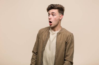 Kahverengi ceketli genç beyaz adam gördüğü bir şey yüzünden şok oluyor..