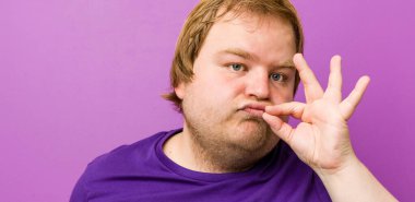 Genç otantik kızıl saçlı, parmakları dudaklarında şişman bir adam sır saklıyor..