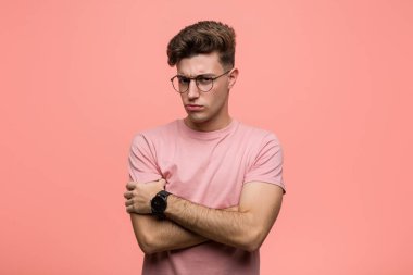 Kafkasyalı genç adam hoşnutsuzca kaşlarını çatıyor, kollarını kavuşturuyor..