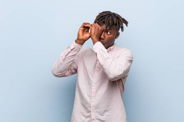 Genç iş adamı afrikalı siyahi adam uzaklara bakıyor ve elini alnında tutuyor..