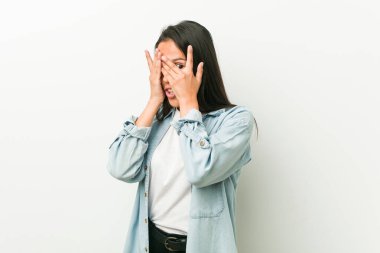 Genç İspanyol kadın parmaklarının arasından korkmuş ve gergin bir şekilde kırpıyor..