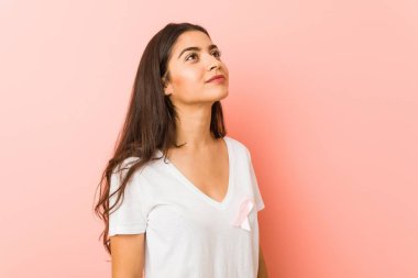 Pembe yayı olan genç arap kadını. Kanserle mücadele kavramı.