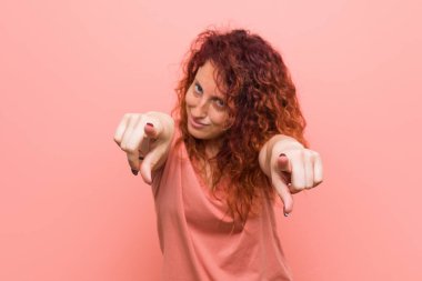 Genç, doğal ve otantik kızıl saçlı, gülümseyen bir kadın..