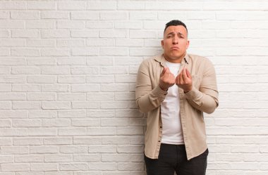 Genç Latin bir adam ihtiyaç jesti yapıyor.