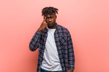 Genç Afrikalı siyahi adam tapınağı parmağıyla işaret ederek, düşünerek, bir göreve odaklandı..