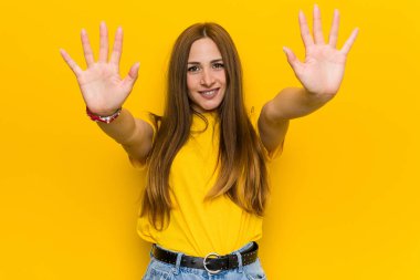 Kızıl saçlı genç kadın on numarayı elleriyle gösteriyor..