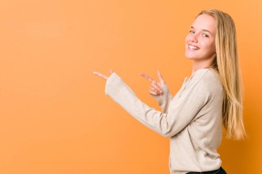 Sevimli ve doğal genç kadın uzakta ön parmakları ile işaret heyecanlı.