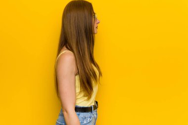 Genç kızıl saçlı, çilli kadın sol tarafa bakıyor, yandan bakıyor..