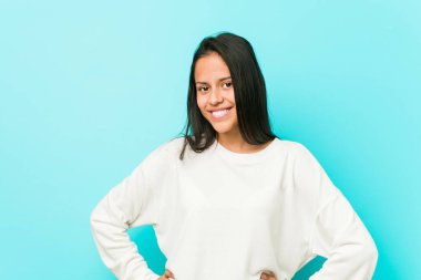 Genç, güzel, kendine güveni tam bir İspanyol kadın ellerini kalçasından ayırmıyor..