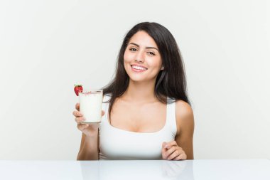Genç İspanyol bir kadın elinde smoothie genç İspanyol bir kadın elinde avokado tostu tutarken mutlu, güler yüzlü ve neşeli