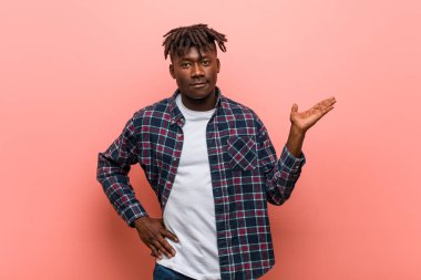 Genç Afrikalı siyah adam bir avuç üzerinde bir kopya alanı gösteren ve bel başka bir el tutarak.