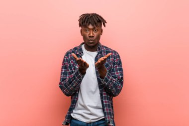 Genç Afrikalı siyah adam dudaklarını katlıyor ve hava öpücüğü vermek için avuç içi tutuyor..