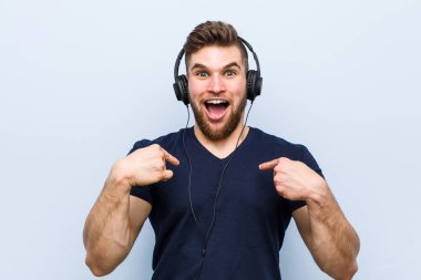 Müzik dinleyen beyaz bir adam kendini göstererek şaşırdı ve gülümsedi..