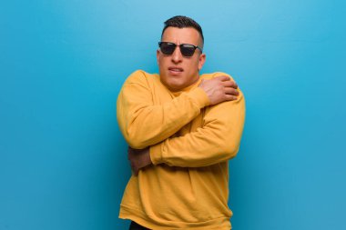 Genç Kolombiyalı adam düşük ateş yüzünden soğuyor.