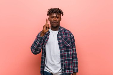 Genç Afrikalı siyahi adam bir numarayı parmağıyla gösteriyor..