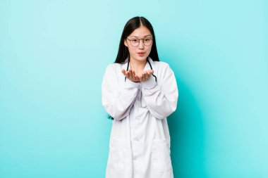 Genç Çinli doktor dudaklarını kıvırıp, avuç içi tutarak hava öpücüğü gönderiyor..