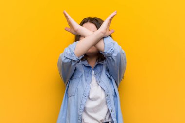 Genç, kıvrımlı, kilolu bir kadın iki kolu çapraz tutuyor, inkar kavramı.